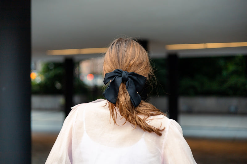 Woman with a black bow in her hair.